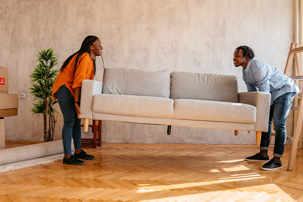 Couple moving boxes into a new home